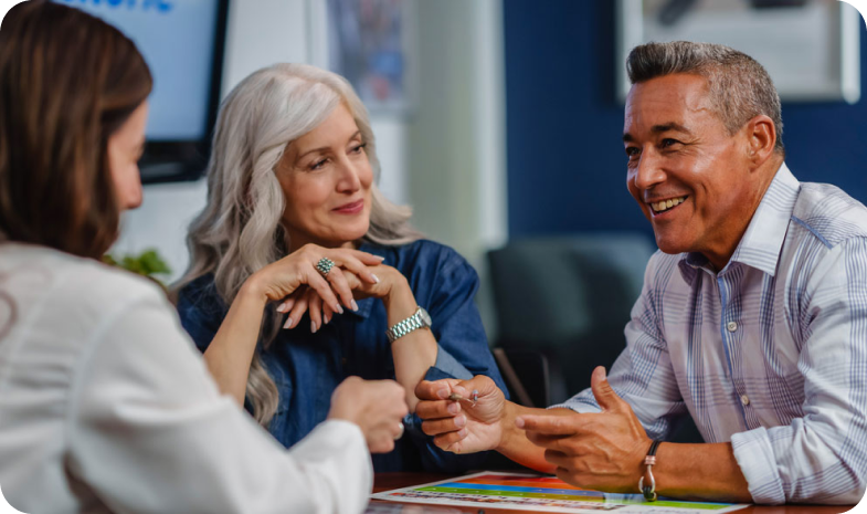 A middle-aged man and woman couple meet with a Beltone hearing aid specialist.